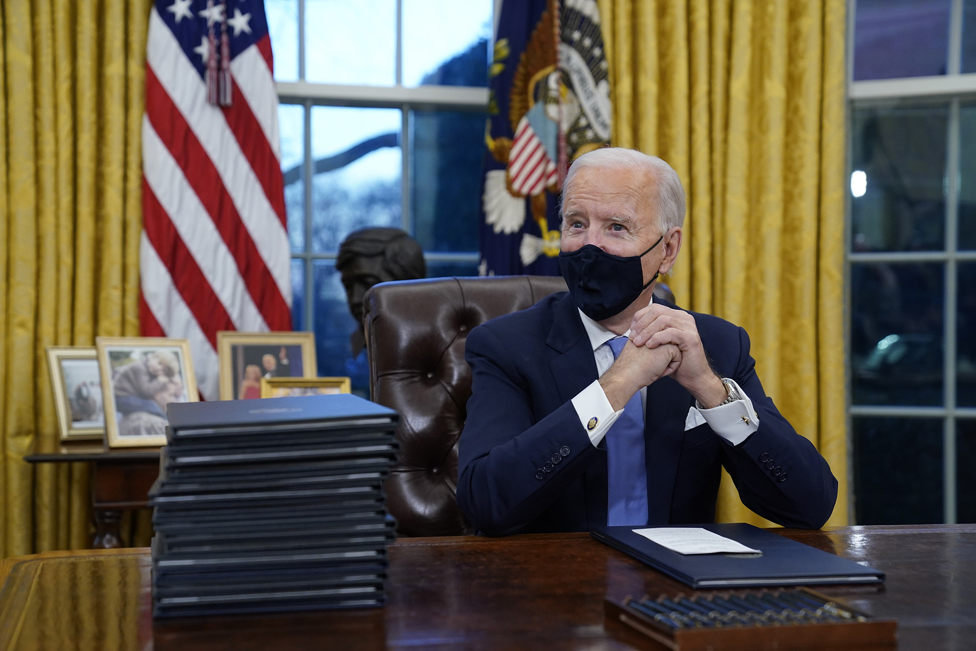 President Joe Biden waits to sign his first executive order in the Oval Office of the White House on Wednesday, Jan. 20, 2021, in Washington.